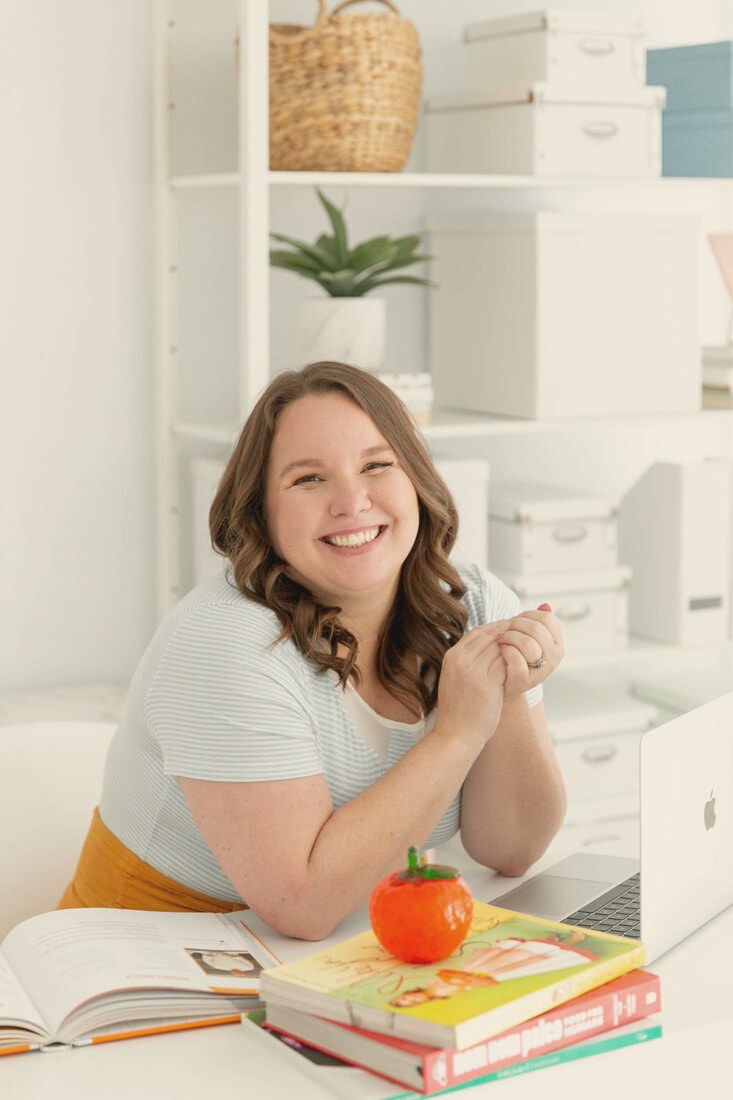 Rosie Gizelt, founder of Click to Table, at her desk with cookbooks and a laptop