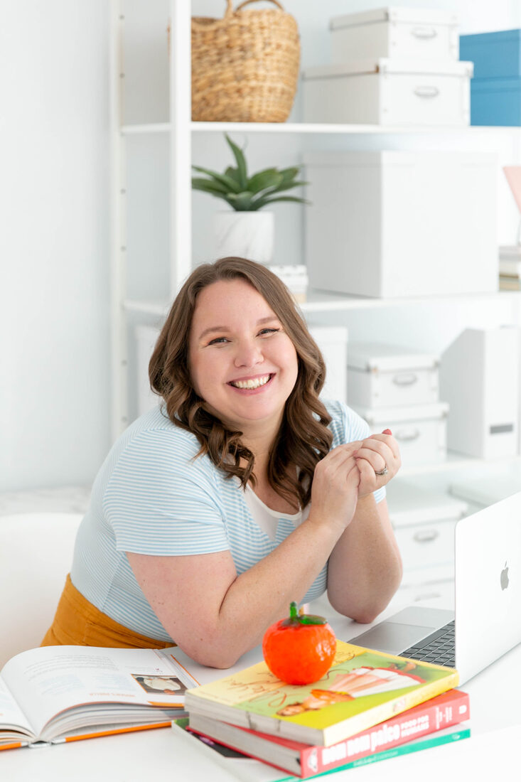 Rosie Gizelt, founder of Click to Table, at her desk with cookbooks and a laptop